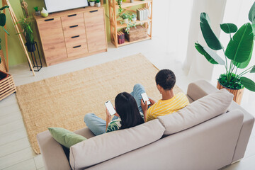 High angle view photo of cute multinational couple sit couch together indoors house living room...