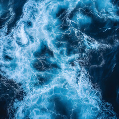 Fototapeta premium A high-angle view of swirling blue ocean waters, showcasing vibrant hues and dynamic patterns created by waves and currents.