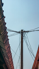 Fototapeta premium Photo of a towering electricity pole with wires stretching in all directions in a place with a beautiful photo angle