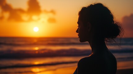 Fototapeta premium woman practicing yoga on a beach, pose silhouetted