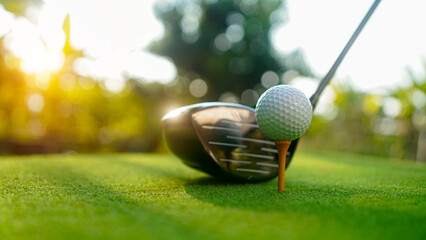 Golf clubs and balls on a green lawn in a beautiful golf course with morning sunshine.