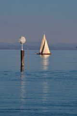 Segelboot auf dem Bodensee im Herbst vor den schneebedeckten Alpen