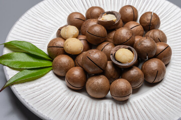 Fototapeta premium Australian Queensland macadamia nuts, or bush, maroochi, bauple nut, with sawn nutshell, fresh harvest