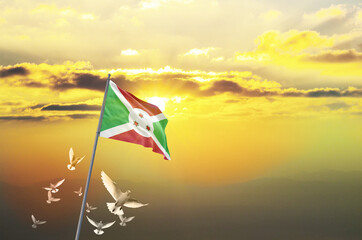 Burundi flag waving with flying doves against sunset or sunrise. Burundi flag for Republic Day and Independence Day.