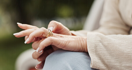 Elderly woman, hands and ring with memory for commitment, marriage and nostalgia for love at park. Closeup, senior person and playing with jewelry for divorce, thinking and promise with gold