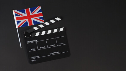 Union Jack flag and clapper board on black background.