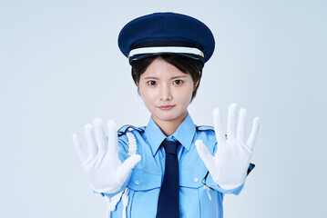 制止するポーズをする女性警備員