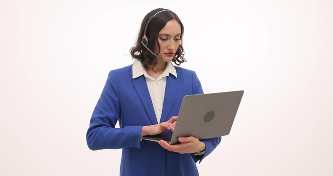 Woman call center worker with special equipment types on laptop. Female employee with earphones and microphone enters information slow motion