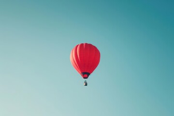 Fototapeta premium A minimalist shot of a lone, red hot air balloon floating in a clear blue sky