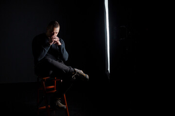 Fototapeta premium Contemplative Man in Dimly Lit Studio Setting
