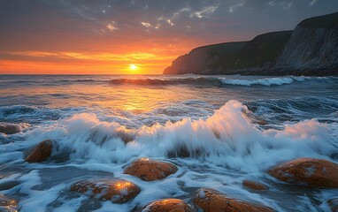 Obraz premium A serene sunset over a rocky beach with waves crashing against the shore.