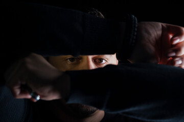 Introspective Gaze Amidst Shadows with Hands Framing the Face