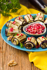 Delicious appetizer of grilled eggplants. Wrapped in rolls with nut paste. Served with pomegranates.