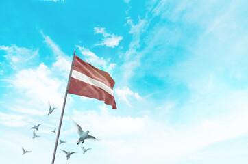 Latvia flag waving with flying doves in beautiful sky. Latvia flag for Republic Day and...