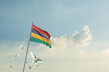 Fototapeta premium Mauritius flag waving with flying doves in beautiful sky. Mauritius flag for Republic Day and Independence Day.