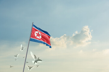 North Korea flag waving with flying doves in beautiful sky. North Korea flag for Republic Day and...