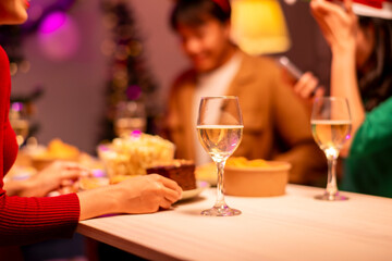 Obraz premium A group of people are sitting around a table with food and drinks
