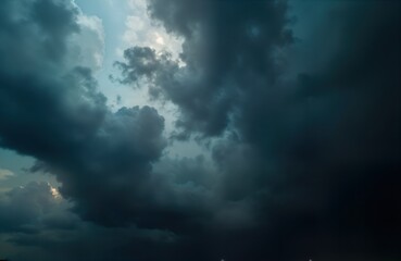 Obraz premium Dark ominous clouds fill sky. Dramatic stormy weather scene. Clouds gather before thunderstorm. Nature background with moody atmosphere. Intense weather conditions visible. Dramatic cloud formations.