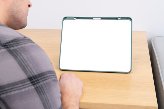 Man looking at planchet with white screen at home