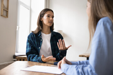 Woman provide helpful information to client or colleague at meeting in office, sit at desk lead...