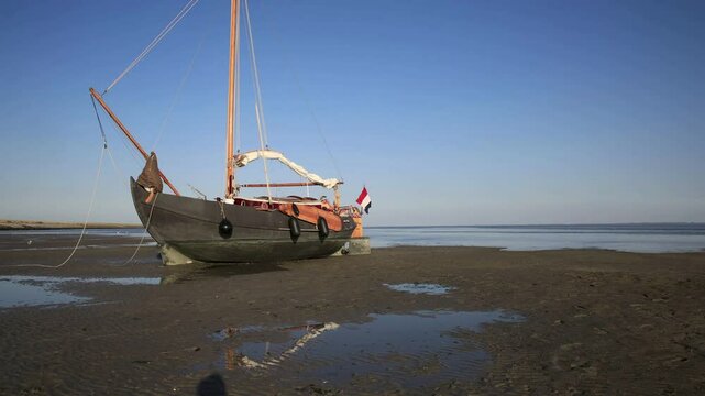 Timpelapse of a classic sailboat showing the uprising tidal movement in the Wadden Sea, Holland