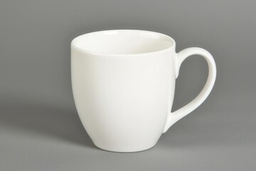 Fototapeta premium A simple, elegant white cup against a neutral grey background, perfect for coffee, tea, or decorative purposes.