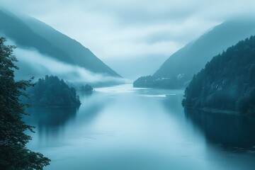 Serene blue-toned lake between misty mountain ranges at dawn, creating a tranquil and ethereal atmosphere.
