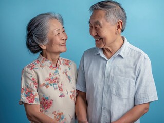 Joyful senior couple indoor studio portrait light blue background close-up emotions