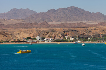 Fototapeta premium Panorama of Sharm el-Sheikh, Sharm El Maya bay. Excursion submarines, Red sea and Sinai mountains on a background. Boat trips and sightseeing in Egypt, Sharm el-Sheikh.