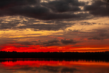 Fototapeta premium A Stunning Sunset Over Serene Lake With Beautiful Reflections in the Calm Waters