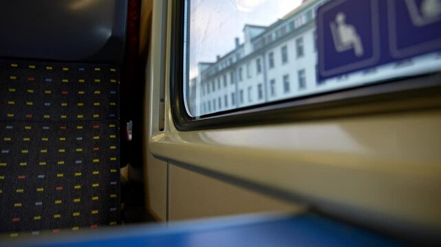 Close-up of seat inside of passenger train passing buildings at Swiss Canton of Z&uuml;rich on an autumn morning. Slow motion movie shot November 15th, 2024, Zurich, Switzerland.