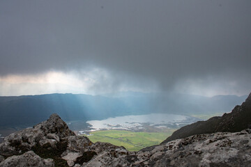 A lake between the rocks in the mountains with stormy sky