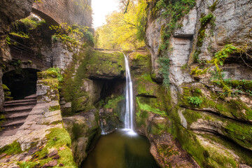 Waterfall at Moulin du Saut, an 18th century derelict mill in a forest of autumn colours on the...