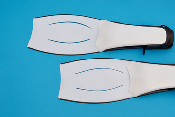 Man swimming with fins in against of white. water underwater nature concept. man sports colored fins on a blue . a man is sporting a blue and white striped shirt with fins and a blue stripes against.