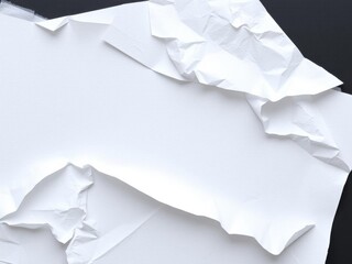 Obraz premium White crumpled and creased paper posters arranged creatively on black backdrop, paper, blank, crumpled