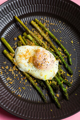 jajko ze szparagami na czarnym talerzu © Mateusz