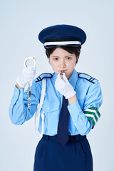 警備員の制服を着て手錠を持つ女性