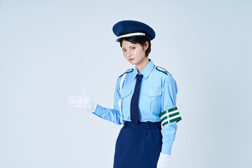 警備員の制服を着て誘導のポーズをする女性