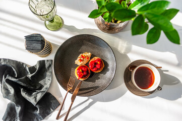 Light breakfast in a restaurant with coffee and pancakes with cherry jam