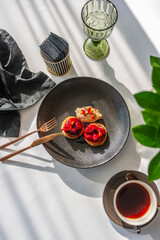 Light breakfast in a restaurant with coffee and pancakes with cherry jam