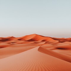Vast, red sand dunes stretch under a clear sky.