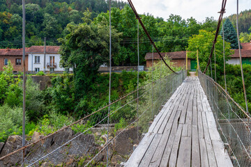 Fototapeta premium One of the two suspension footbridges over Vidima River in the Bulgarian Fore-Balkan village of Debnevo, Troyan Municipality