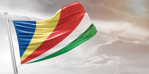 Seychelles national flag cloth fabric waving on beautiful grey Background.