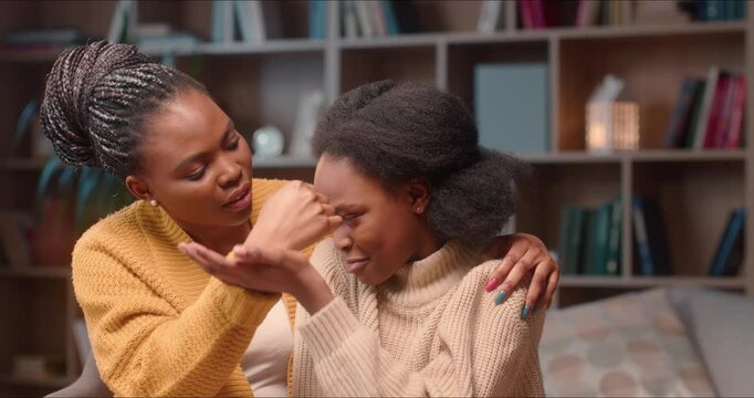 Worried loving african american mother comforting little upset kid daughter. Girl crying, mother talking giving support or apologizing, mom parent helping small child with problem sitting.