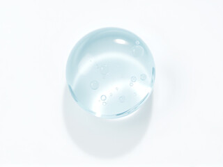clear water droplet resting on a smooth surface, illustrating the beauty of natural shapes and reflections in bright light