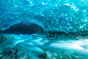 Under Iceland's Vatnajökull Glacier lies a mesmerizing ice cave with radiant blue walls and a...
