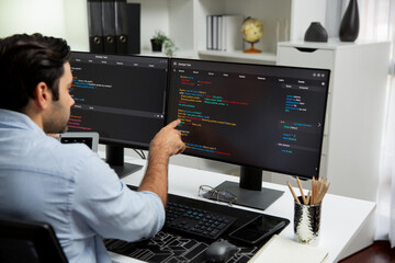 Concentrating in smart IT developer working software development coding on two pc screen, creating...