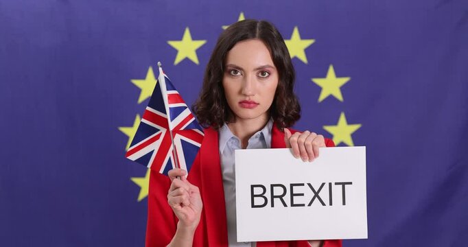Woman holds paper sign with word Brexit and British flag standing against EU emblem. Lady raises concerns over British economic impact on Europe