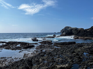 Rocky Coastal Scene with Blue Sky and Waves