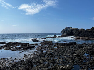 Rocky Coastal Landscape With Blue Sky and Ocean Waves